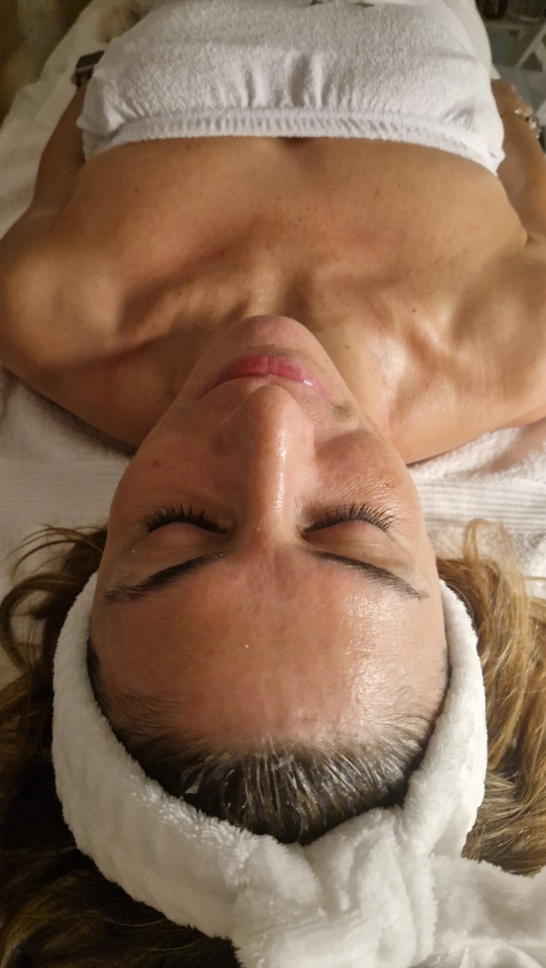 Klijentkinja opušteno leži na krevetu za tretman, spremna za početak Thalgo Silicium Lift masaze lica. Lice je u fokusu i jasno se vide crte lica